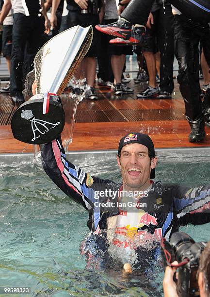 Red Bull's Australian Driver Mark Webber celebrates in the pool after winning the Monaco Grand Prix 2010 at the Red Bull Formula 1 Energy Station on...