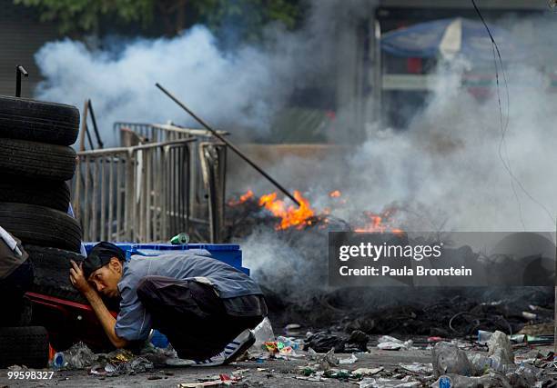 Redshirt protesters take cover from gunfire coming from the military as the violence in central Bangkok continues on May 16, 2010 in Bangkok,...