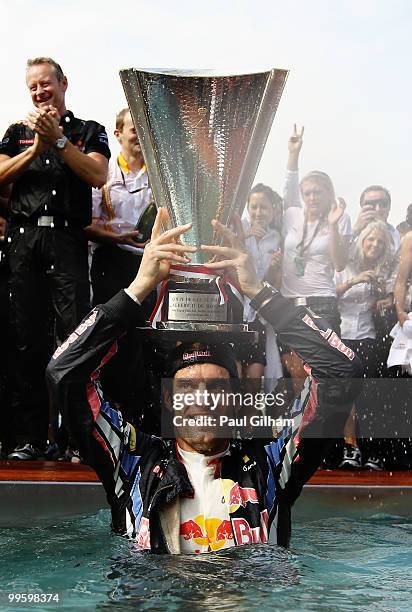 Mark Webber of Australia and Red Bull Racing celebrates by diving into the Red Bull Energy Station swimming pool after winning the Monaco Formula One...