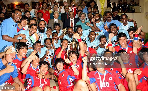 South Korean and Indian field hockey players celebrate with the winner's trophy of the 19th Sultan Azlan Shah Cup field hockey tournament in the...