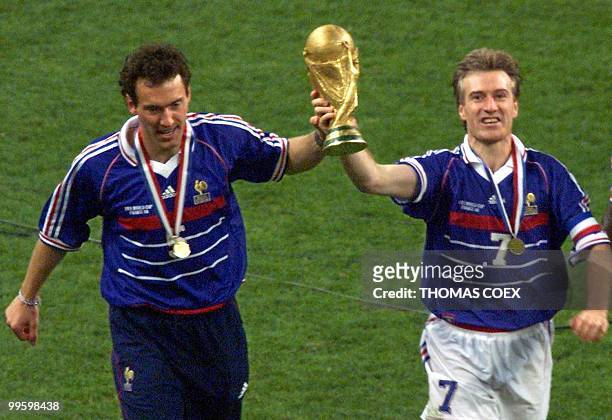 French captain Didier Deschamps and Laurent Blanc hold the FIFA trophy after the 1998 Soccer World Cup final between Brazil and France at Stade de...