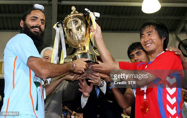 India's field hockey player Arjun Halappa and South Korean counterpart Kim Yong Beel lift up the winner's trophy of the 19th Sultan Azlan Shah Cup...