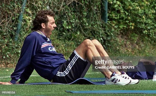 French national soccer mid-fielder Zinedine Zidane enjoys a rest as teammate Laurent Blanc yawns 04 July in Clairefontaine, near Paris, during a...