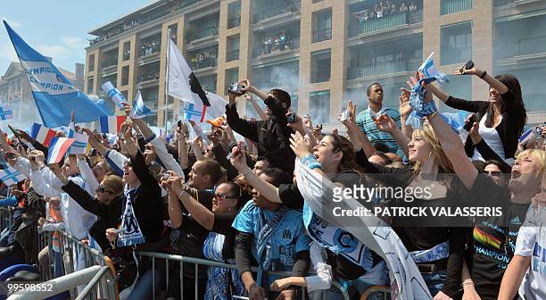 Olympique de Marseille supporters celebrate Marseille's players as they parade in buses following the team's victory in the French L1 football...