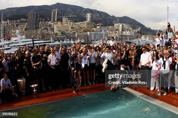 Mark Webber of Australia and Red Bull Racing celebrates by diving into the Red Bull Energy Station swimming pool after winning the Monaco Formula One...