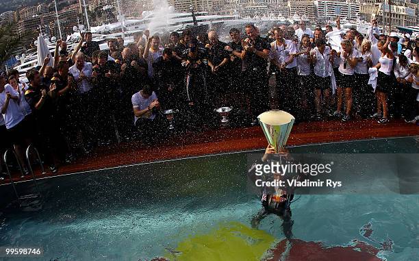 Mark Webber of Australia and Red Bull Racing celebrates by diving into the Red Bull Energy Station swimming pool after winning the Monaco Formula One...