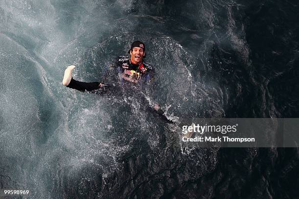 Mark Webber of Australia and Red Bull Racing celebrates by diving into the harbour after winning the Monaco Formula One Grand Prix at the Monte Carlo...