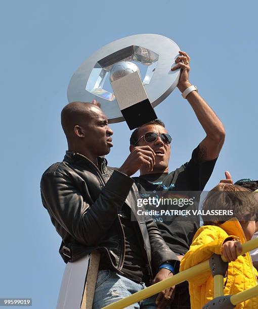 Olympique de Marseille players Vitorino Hilton with the French L1 trophy and Charles Kabore celebrate as they parade in buses following the team's...