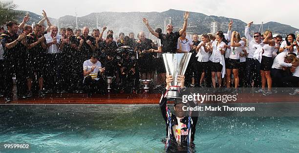 Mark Webber of Australia and Red Bull Racing celebrates by diving into the Red Bull Energy Station swimming pool after winning the Monaco Formula One...