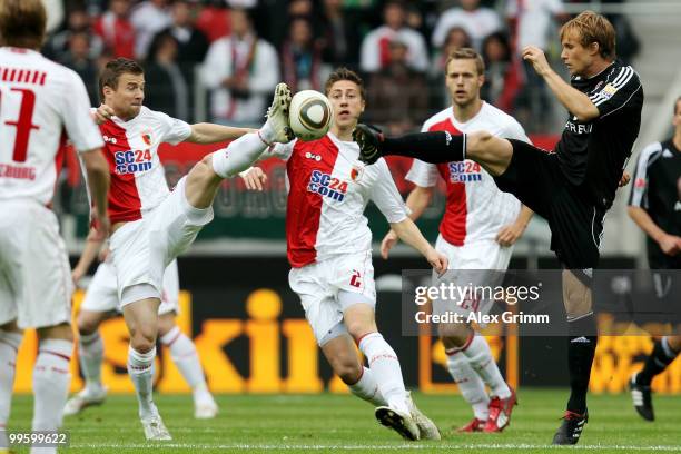 Daniel Baier of Augsburg is challenged by Andreas Ottl of Nuernberg during the Bundesliga play off leg two match between FC Augsburg and 1. FC...