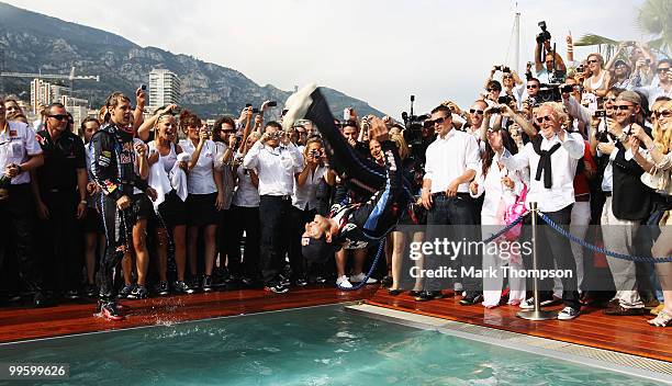 Mark Webber of Australia and Red Bull Racing celebrates by doing a back flip into the Red Bull Energy Station swimming pool after winning the Monaco...