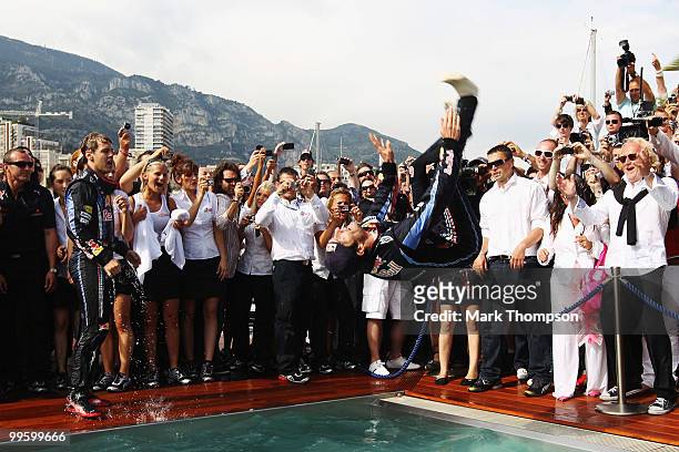 Mark Webber of Australia and Red Bull Racing celebrates by doing a back flip into the Red Bull Energy Station swimming pool after winning the Monaco...