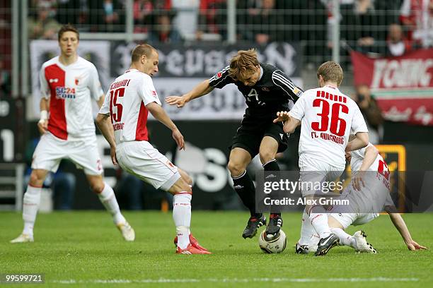 Andreas Ottl of Nuernberg is challenged by Jens Hegeler, Dominik Reinhardt, Stephan Hain and Daniel Brinkmann of Augsburg during the Bundesliga play...