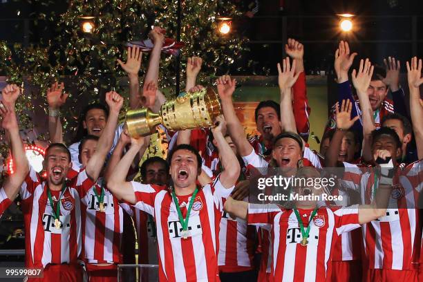 Mark van Bommel of Bayern Muenchen lifts the DFB Cup trophy following his team's victory at the end of the DFB Cup final match between SV Werder...