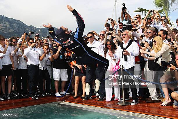 Mark Webber of Australia and Red Bull Racing celebrates by doing a back flip into the Red Bull Energy Station swimming pool after winning the Monaco...