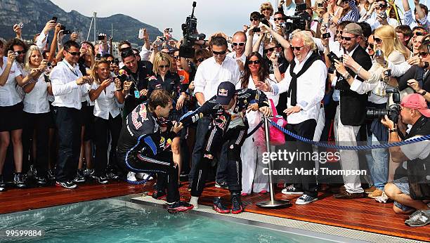 Sebastian Vettel of Germany and Red Bull Racing tries to throw race winner Mark Webber of Australia and Red Bull Racing into the Red Bull Energy...