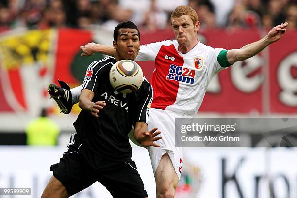 Maxim Choupo-Moting of Nuernberg is challenged by Uwe Moehrle of Augsburg during the Bundesliga play off leg two match between FC Augsburg and 1. FC...