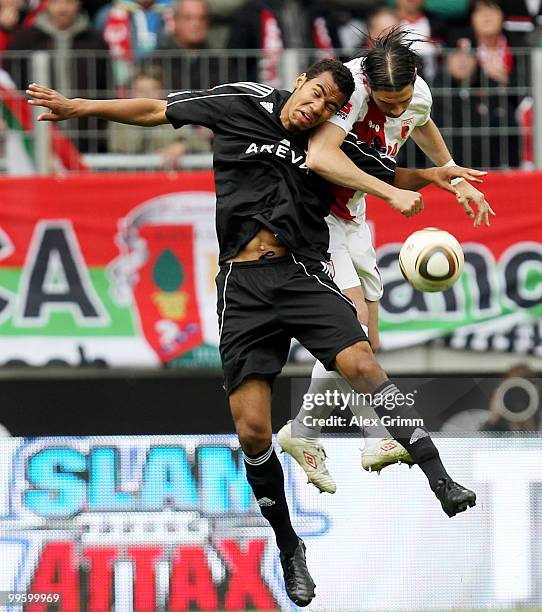 Maxim Choupo-Moting of Nuernberg jumps for a header with Sandor Torghelle of Augsburg during the Bundesliga play off leg two match between FC...