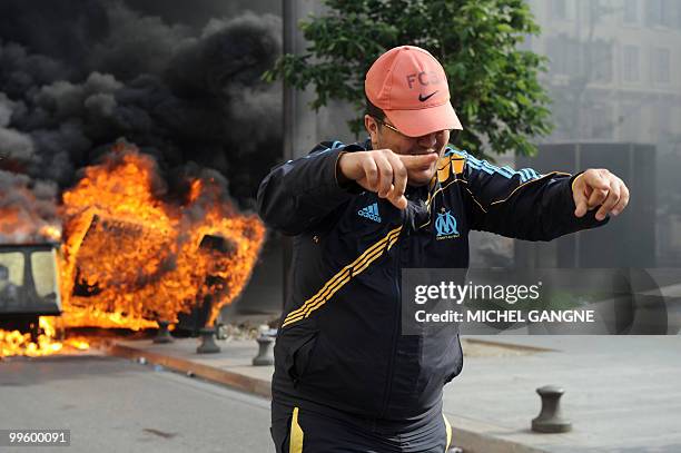 An Olympique de Marseille supporter walks away from a dustbin on fire, on May 16, 2010 in Marseille southern France, where a few incidents broke out...