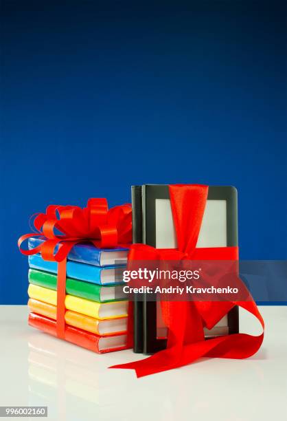 books tied up with ribbon and electronic book reader against blue background - e reader - fotografias e filmes do acervo