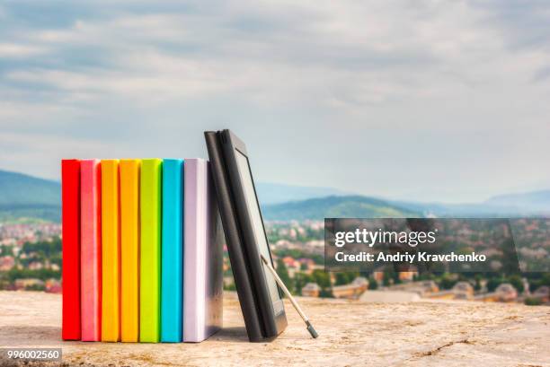 stack of colorful books with e-book reader - e reader - fotografias e filmes do acervo