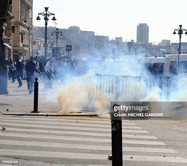 People go away from tear gas smoke on May 16, 2010 in Marseille southern France during a street clash that broke out after Olympique de Marseille's...