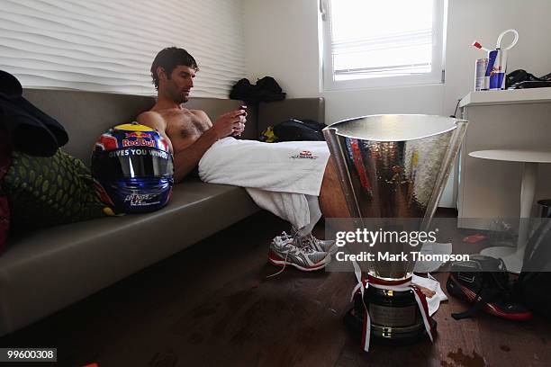 Mark Webber of Australia and Red Bull Racing relaxes in his changing room after ending up in the harbour while celebrating his victory in the Monaco...