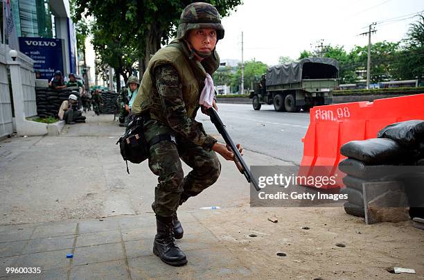 Thai soldier runs to a bunker for cover during continuing street violence on May 16, 2010 in Bangkok, Thailand. Protesters and military clashed for a...