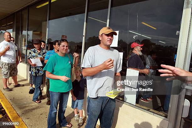 People that are filing claims against BP stand in line in front of a claims office on May 16, 2010 in Bayou La Batre, Alabama. BP says they are...