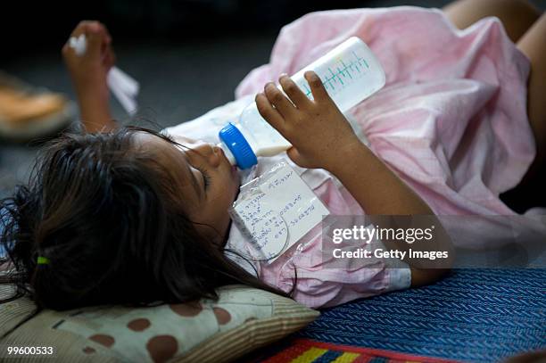 Girl with a piece of paper with his personal details drinks milk while at Wat Pathum Wanaram on May 16, 2010 in Bangkok, Thailand. The temple is...