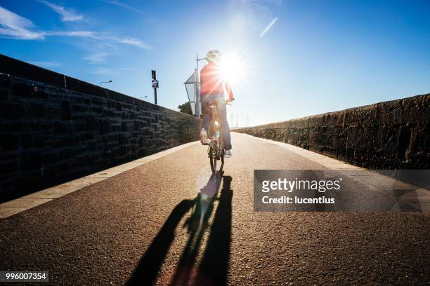 senior vrouw rijden fiets op fietspad - folding bike stockfoto's en -beelden
