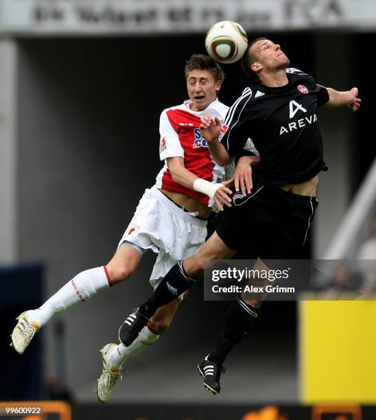 Jens Hegeler of Augsburg jumps for a header with Christian Eigler of Nuernberg during the Bundesliga play off leg two match between FC Augsburg and...