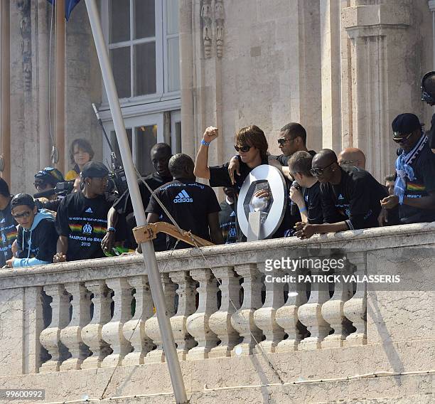 Marseille's Brazilian goalkeeper Andrade and Edouard Cisse hold the L1 trophy flanked by teammates as they celebrate on the balcony of Marseille town...