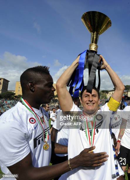 Inter Milan's Argentinian defender and captain Javier Aldemar Zanetti and forward Mario Balotelli celebrates with the trophy after his team defeated...