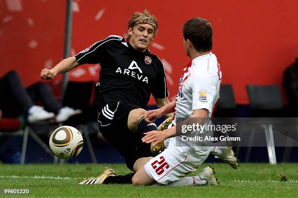 Marcel Risse of Nuernberg is challenged by Daniel Baier of Augsburg during the Bundesliga play off leg two match between FC Augsburg and 1. FC...