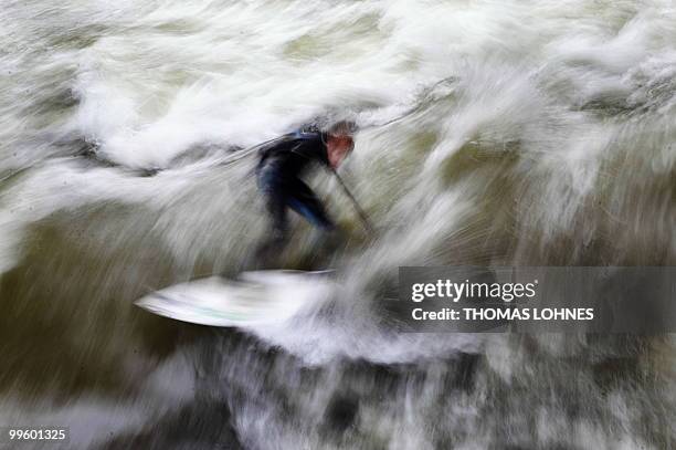 Man surfs on a wave made by the fast moving water of the River Isar in the southern German city of Munich on May 15, 2010. River surfing has become...