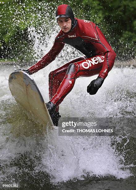 Man surfs on a wave made by the fast moving water of the River Isar in the southern German city of Munich on May 15, 2010. River surfing has become...