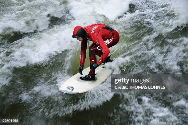Man surfs on a wave made by the fast moving water of the River Isar in the southern German city of Munich on May 15, 2010. River surfing has become...