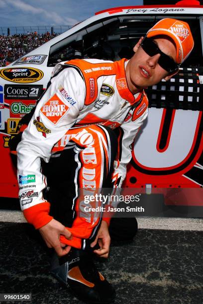 Joey Logano, driver of the The Home Depot Toyota, kneels on the grid prior to the NASCAR Sprint Cup Series Autism Speaks 400 at Dover International...