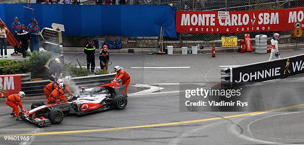 Jenson Button of Great Britain and McLaren Mercedes walks back to the pits after retiring early with an engine problem during the Monaco Formula One...