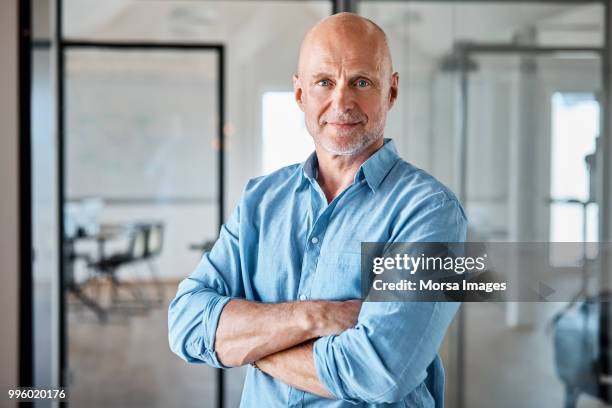 portrait of confident executive with arms crossed - old man looking at camera stock-fotos und bilder