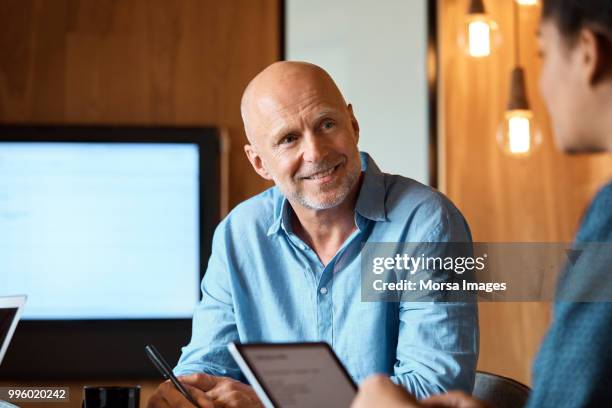 businessman discussing with colleague in office - old man young woman stock pictures, royalty-free photos & images