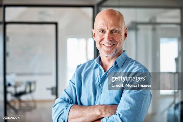 portrait of smiling businessman with arms crossed - balding foto e immagini stock