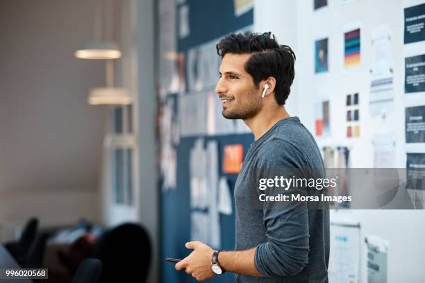 businessman using wireless headset at office - man standing and gesturing stock-fotos und bilder