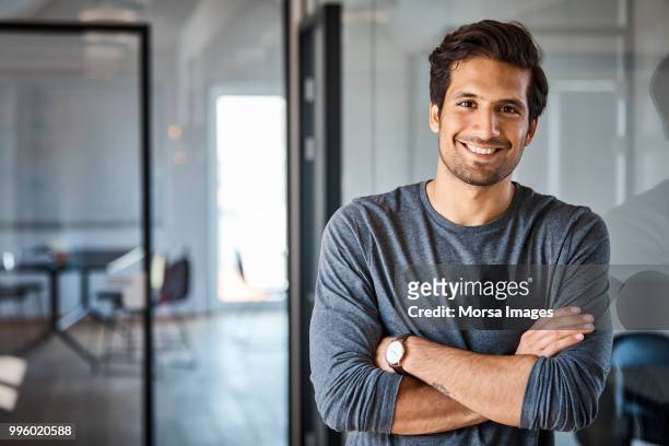 portrait of businessman with arms crossed - young men stock pictures, royalty-free photos & images