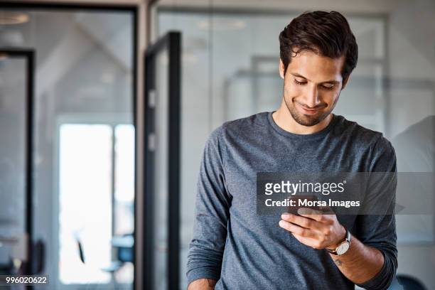 professional using mobile phone at office - portable information device stockfoto's en -beelden