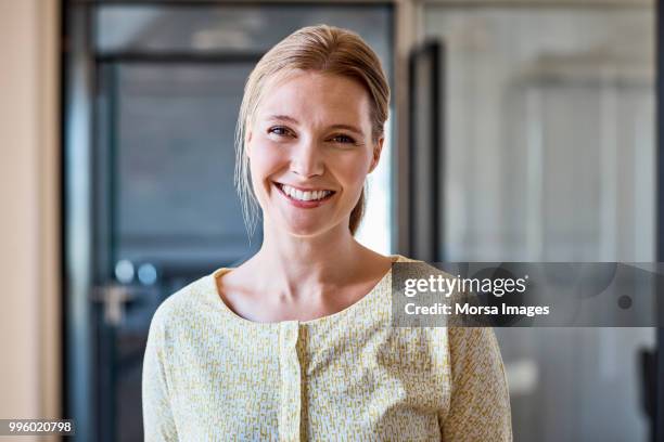 portrait of smiling female professional at office - in de camera kijken stockfoto's en -beelden