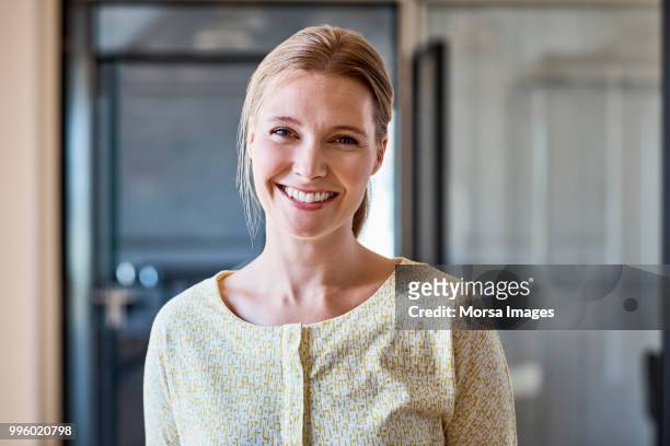 portrait of smiling female professional at office - woman smiling office stock pictures, royalty-free photos & images