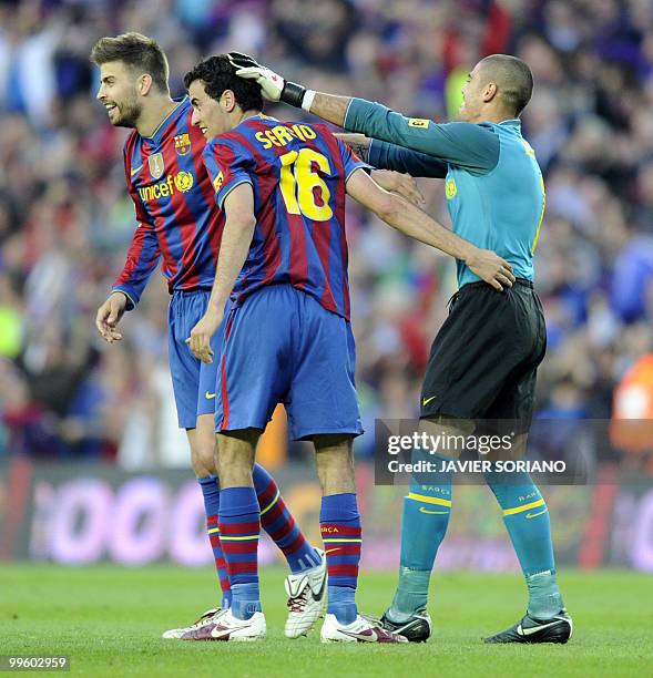 Barcelona's goalkeeper Victor Valdes celebrates celebrates with Barcelona's midfielder Sergio Busquets and Barcelona's defender Gerard Pique after...