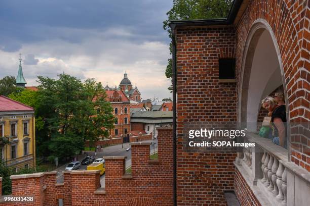 Tourists are seen on a balcony of Wawel Castle in Krakow. Krakow is the second largest city in Poland and it is located in the southern part of the...